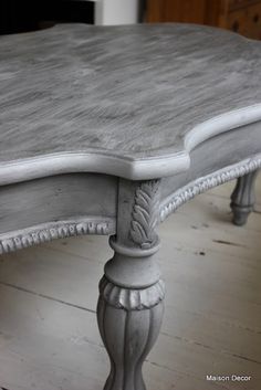 an old table is painted gray with white trim