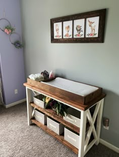 a baby's crib in the corner of a room with two pictures on the wall