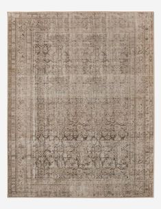 an antique style rug in beige and brown tones with a faded design on the middle