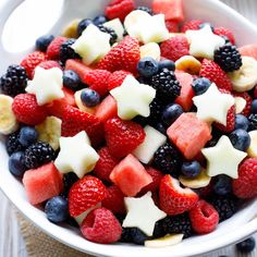 a white bowl filled with fruit topped with stars