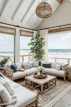 a living room filled with lots of furniture next to an ocean front window on top of a wooden floor