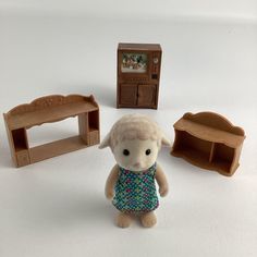 a stuffed animal is standing next to some toys on a white surface with an open bookcase