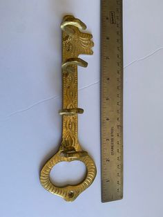 an old brass door handle next to a ruler