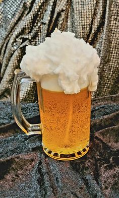 a mug filled with foam sitting on top of a table