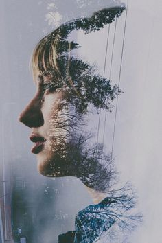 a woman's face with trees reflected in it