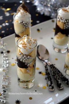 three desserts in small glass containers on a table with confetti and star decorations