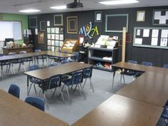 an empty classroom with desks and chairs in front of the chalkboard wall that has pictures on it