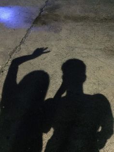 the shadow of a person holding a cell phone