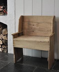 a wooden bench sitting next to a fire place