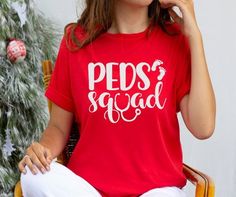 a woman sitting in a chair wearing a red shirt with the words peps squad on it