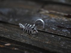 a silver fish ring sitting on top of a wooden table