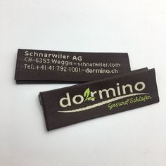 two black and white tags with the words dornino on them are sitting next to each other