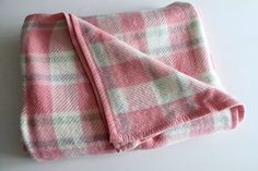 a pink and white checkered blanket laying on top of a table