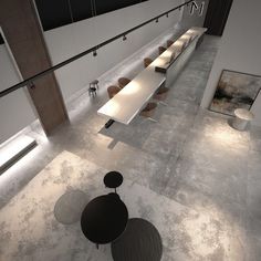 an empty room with tables and benches in the center is lit by lights from above