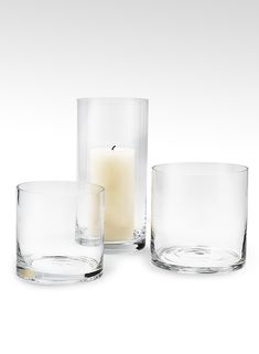 three clear glass vases with one candle in the middle and two on each side