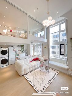 a living room filled with white furniture and lots of windows next to a tall building