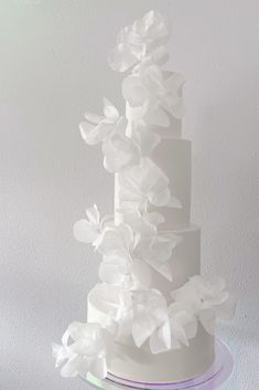 a three tiered white cake with flowers on top