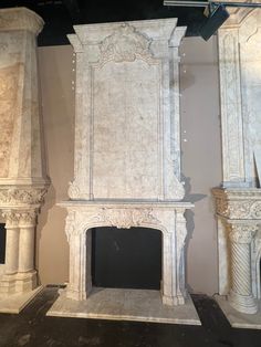 an old fireplace in the middle of a room with columns and pillars on either side