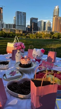 a table topped with cakes and desserts on top of a white cloth covered field