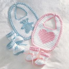 two crocheted baby bibs and booties are laying on a white sheet