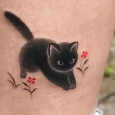 a black cat with red flowers on it's leg