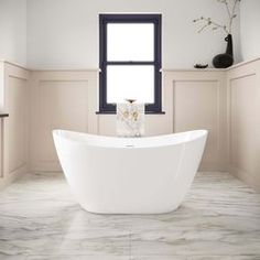 a white bath tub sitting in a bathroom next to a window