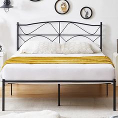 a bed with three clocks on the wall above it and below it is a yellow blanket