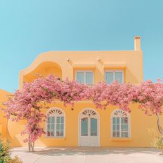 a yellow house with pink flowers on it