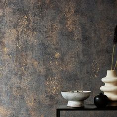 two white vases sitting on top of a table next to a black and white bowl