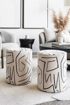 two black and white stools sitting on top of a rug in a living room