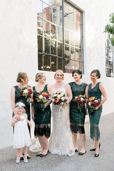 a group of women standing next to each other in front of a building with windows