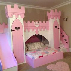 a child's bedroom with a pink castle bed and slide