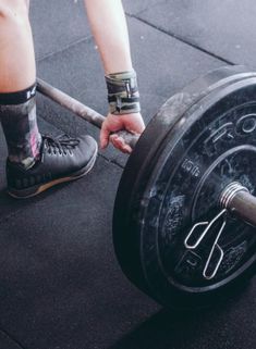 a person is holding a barbell on the ground