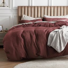 a bed with a red comforter and white pillows