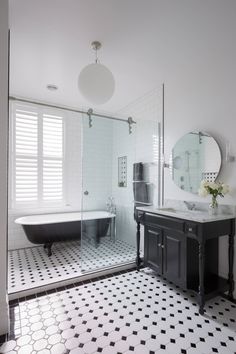 a black and white bathroom with a claw foot tub