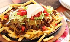 a plate topped with fries covered in cheese and chili