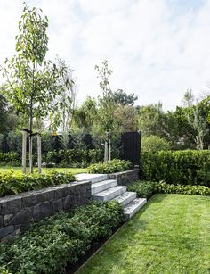 an outdoor garden with stone steps and green grass