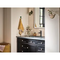 a bathroom with a sink, mirror and towels hanging on the wall next to it