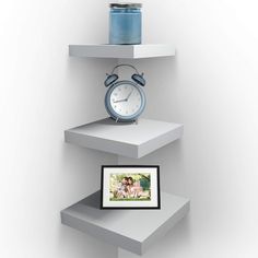 an alarm clock is sitting on top of three shelves