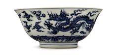 a blue and white porcelain bowl with dragon designs on the outside, sitting in front of a white background