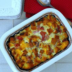 a casserole dish with ham and cheese in it next to a serving spoon