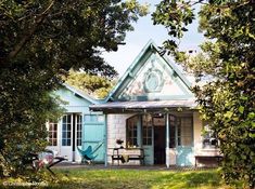 a small blue house sitting in the middle of trees