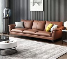 a brown leather couch sitting on top of a white rug