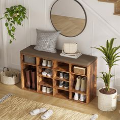 an entryway with shoes and plants on the floor next to a wooden shelf filled with slippers