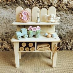 a small wooden toy bench with toys on it's shelf and some other items