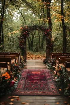 an outdoor wedding ceremony with flowers and greenery on the aisle, decorated with red runner rug