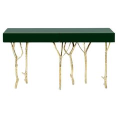 a table that has some branches on it and is green with gold leafing around the edges