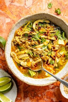 a white bowl filled with soup next to sliced limes