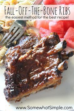 a white plate topped with meat, pasta and watermelon wedges next to a fork