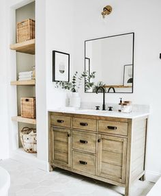 a bathroom vanity with two sinks and mirrors on the wall, along with other items